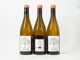 trois bouteilles de vin posées l'une à côté de l'autre sur une table