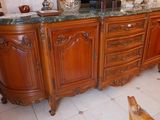 un chien qui se tient devant une commode