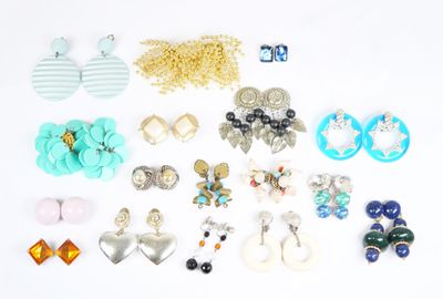 de nombreuses paires de boucles d'oreilles et de colliers posés sur un fond blanc