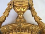 a gold clock with a bird on top of it
