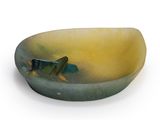 a small bowl with a fish on it on a white surface