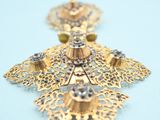 gold filigree filigree leaf earrings on a blue background
