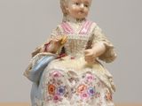 a figurine of a woman sitting on a table