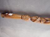 a wooden stick with a carving of a man and a woman on it