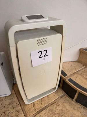 a small white refrigerator sitting on the floor next to a wall