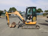 une petite excavatrice garée sur un parking