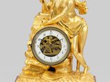 une horloge en or surmontée d'une statue