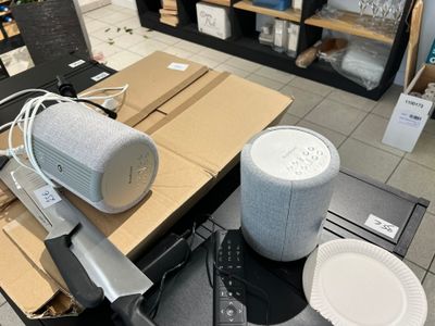 une table sur laquelle se trouvent un haut-parleur, un couteau et d'autres objets