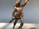 bronze statue of a man with a gun on a white surface