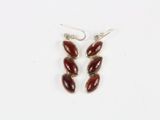 une paire de boucles d'oreilles auxquelles sont suspendues des perles de verre rouges