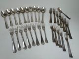 many forks and spoons laid out on the table