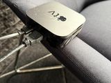 une chaise argentée avec une assise noire sur laquelle figure un logo en forme de pomme argentée