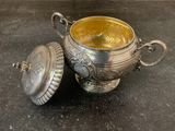 a silver cup with a lid sitting on a table