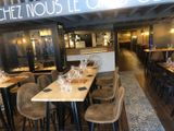 tables and chairs are lined up in a restaurant with a sign above them