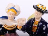 two figurines of a man and a woman holding hands