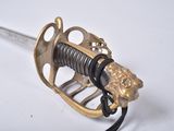 a sword with a lion head on it on a white surface