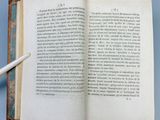 an open book with a pen resting on top of it on a blue surface