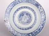 une photo d'une assiette bleue et blanche posée sur un socle