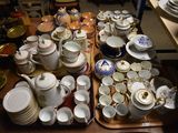 de nombreuses assiettes et bols sur la table, sur lesquels sont posées des tasses et des soucoupes