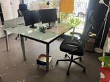 a desk with two monitors and a chair in a room