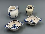 four pieces of blue and white pottery sitting on a gray surface