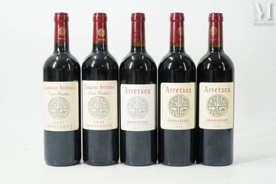 six bottles of wine are lined up in a row on a white surface