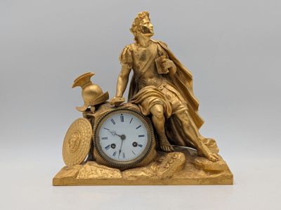 a gold statue of a man sitting on top of a clock