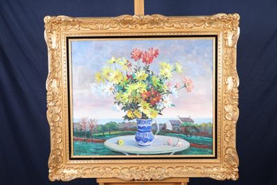 un tableau représentant des fleurs dans un vase bleu posé sur un chevalet