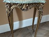 a small table with a marble top on a wooden floor