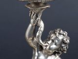 an antique silver plate with a boy holding a bowl on it