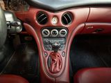 the interior of a car with red leather seats and dashboard controls