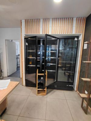 une pièce dotée d'une porte vitrée et d'étagères