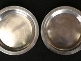 pair of silverplated serving dishes on black background
