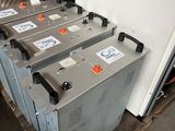 several batteries are lined up on a pallet in a warehouse
