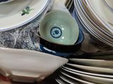 a pile of plates and bowls sitting on a table