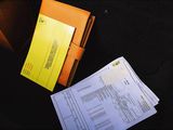a folder of papers sitting on a table next to a purse