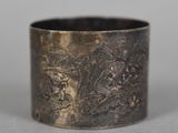 an antique silver cuff bracelet with a design of flowers and leaves