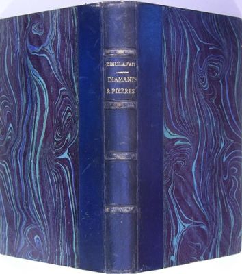 un vieux livre à la couverture bleue posé sur une table blanche