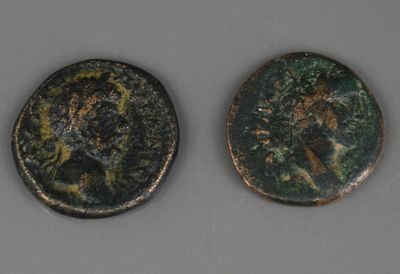 deux pièces de monnaie romaines anciennes, dont l'une représente un visage et l'autre une tête