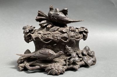 une statue représentant un oiseau perché sur une souche d'arbre