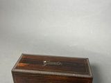 an antique wooden box with beading on the lid