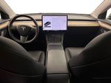 the interior of a tesla vehicle with a laptop on the dashboard