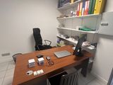 un bureau sur lequel se trouve un ordinateur portable, dans un coin de la pièce