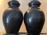 deux vases noirs posés sur une table dans une pièce