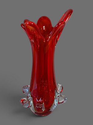 un vase en verre rouge posé sur une table