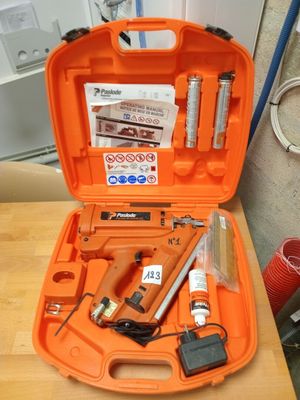 une mallette orange contenant des outils, posée sur une table