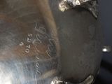 a silver plate with a bird on it on a table