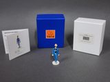 a small figurine of a man standing next to a blue box