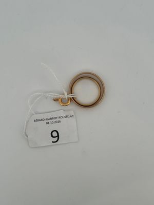 a small gold ring with a tag attached to it