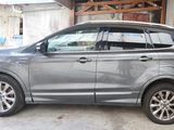 une voiture argentée garée dans un garage à côté d'une camionnette